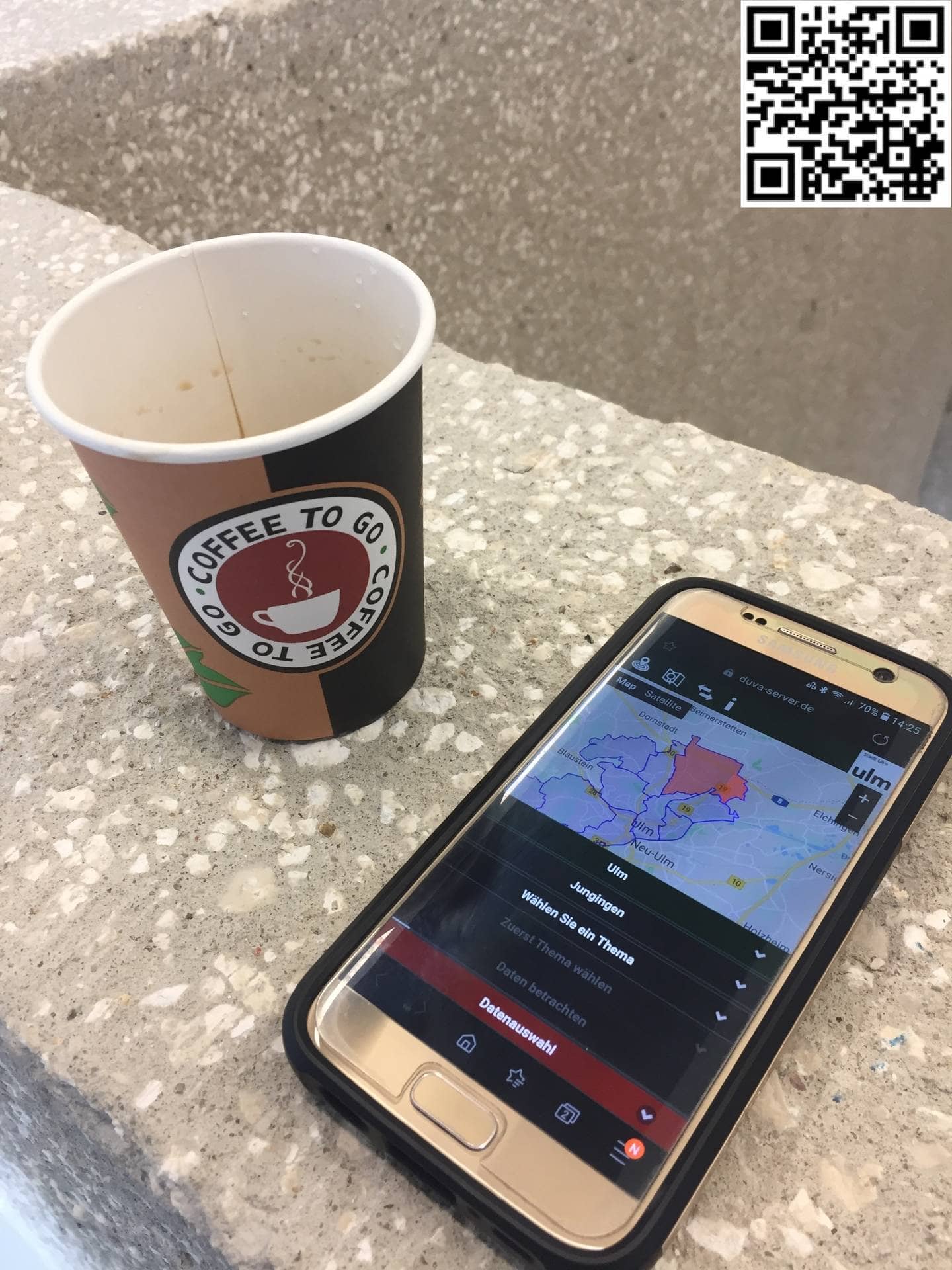 Kaffeebecher und Handy mit Kosis App